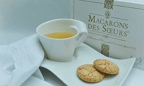 Macarons réalisés par la Maison des soeurs Macarons, ils sont accompagnés d'une tasse de thé. 